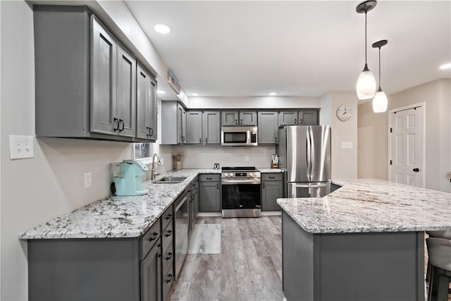 kitchen featuring gray cabinets, appliances with stainless steel finishes, and pendant lighting