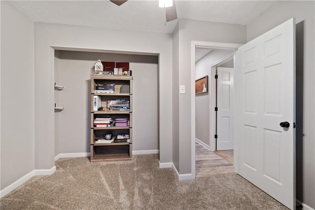 hallway featuring carpet and a textured ceiling