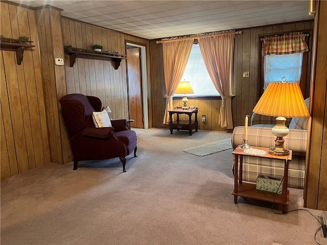 sitting room featuring wooden walls and carpet flooring