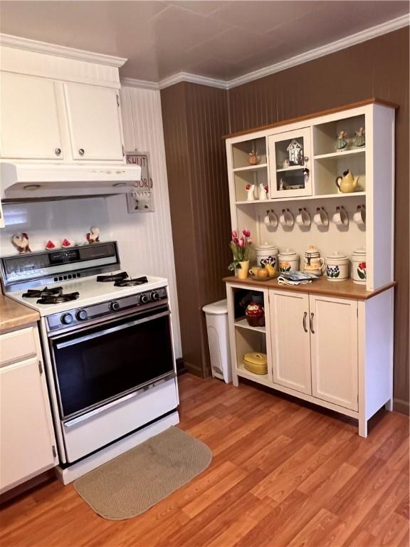 kitchen featuring white cabinetry, light wood-type flooring, crown molding, and white gas range oven