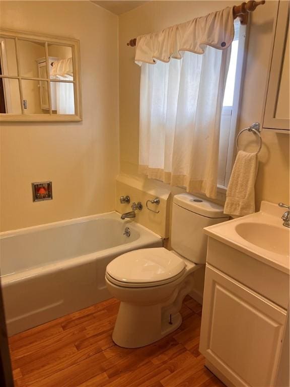 bathroom featuring vanity, hardwood / wood-style floors, a bathtub, and toilet