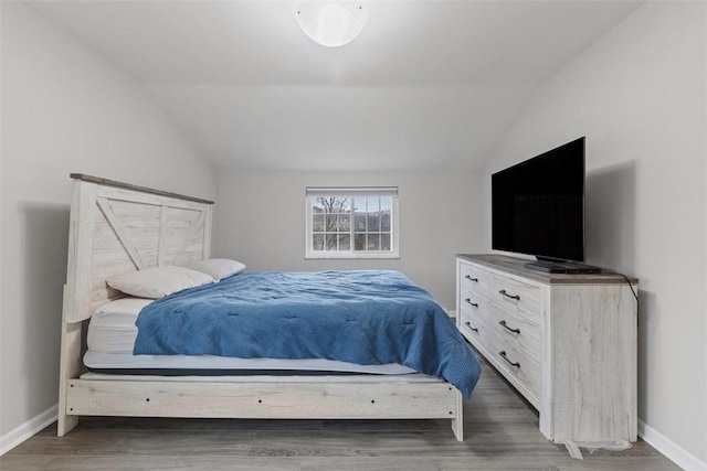 bedroom featuring dark hardwood / wood-style flooring and vaulted ceiling