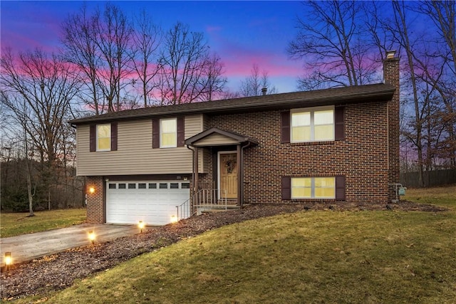 bi-level home with a garage and a yard