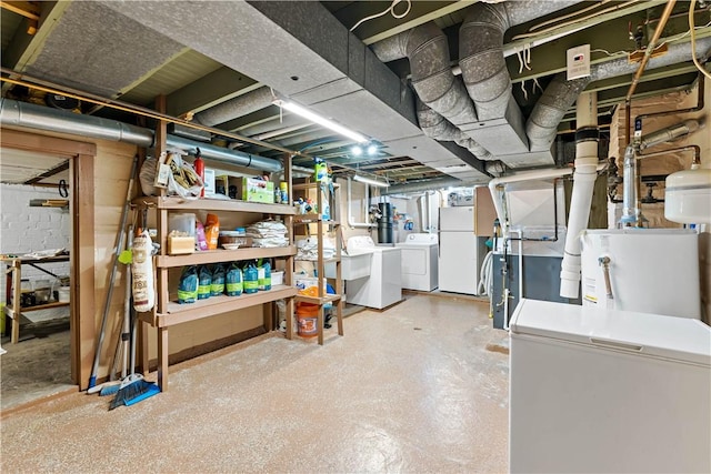 basement with fridge, washing machine and dryer, white fridge, and gas water heater