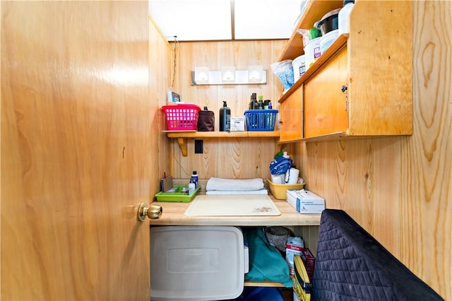 laundry room featuring cabinets, washing machine and clothes dryer, and wood walls