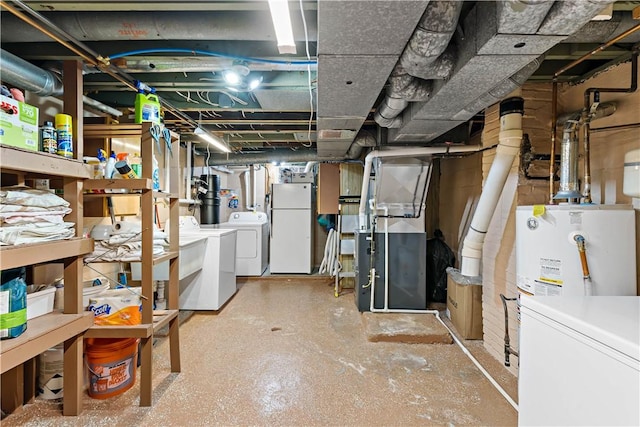 basement with gas water heater, white fridge, heating unit, and independent washer and dryer