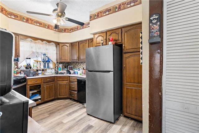 kitchen with light hardwood / wood-style flooring, stainless steel refrigerator, ceiling fan, black dishwasher, and decorative backsplash