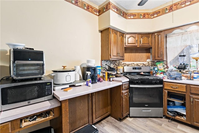 kitchen featuring backsplash, light hardwood / wood-style flooring, and appliances with stainless steel finishes