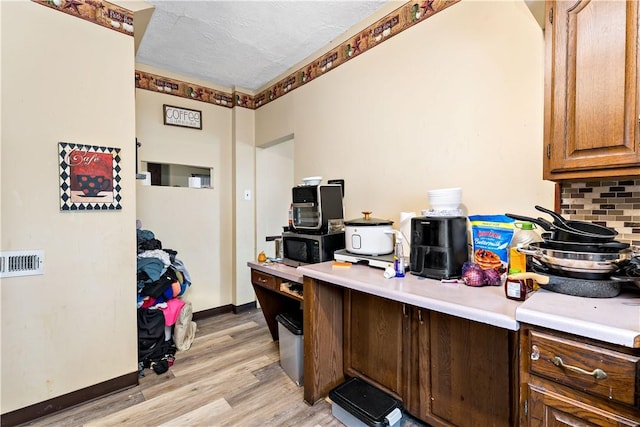 home office featuring light hardwood / wood-style floors and a textured ceiling