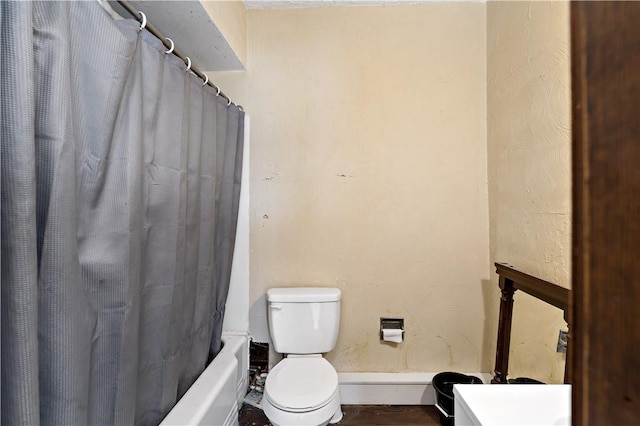 bathroom featuring shower / bathtub combination with curtain and toilet