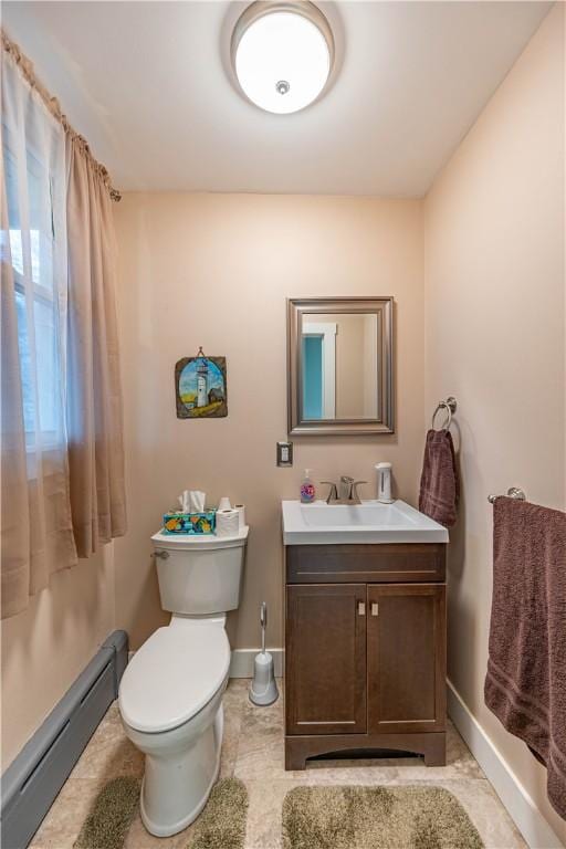 bathroom with vanity, toilet, and baseboard heating