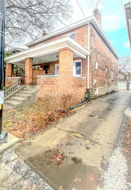 view of side of home with covered porch