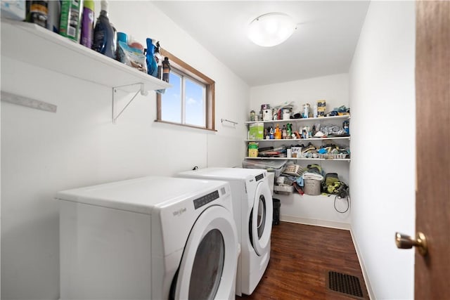 laundry area with dark wood-type flooring and washer and clothes dryer