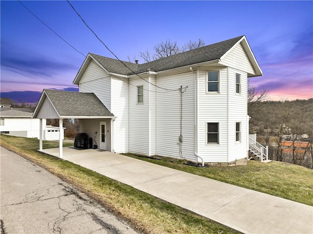 view of front of house featuring a carport and a yard