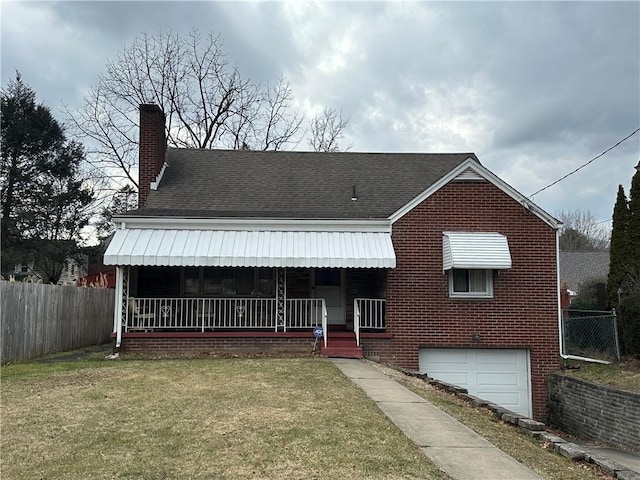 view of front facade with a chimney, covered porch, fence, a front lawn, and brick siding