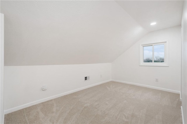 bonus room featuring vaulted ceiling and light carpet