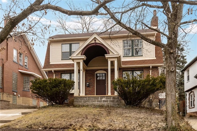 view of front facade with brick siding and a chimney