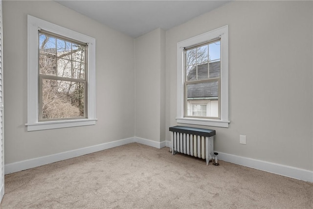 unfurnished room featuring light carpet and radiator