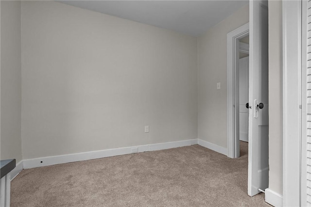 unfurnished bedroom with light colored carpet and baseboards