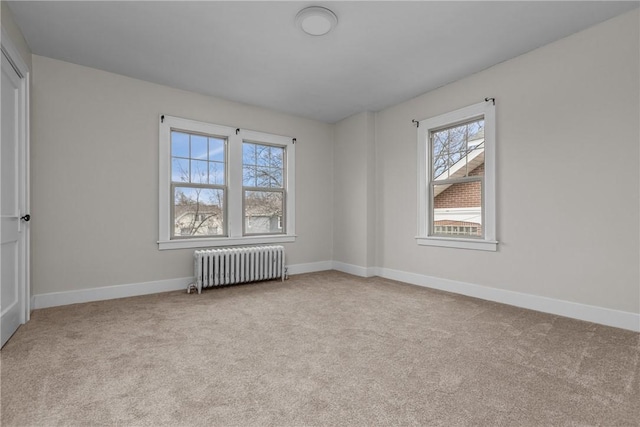 carpeted spare room with baseboards and radiator heating unit