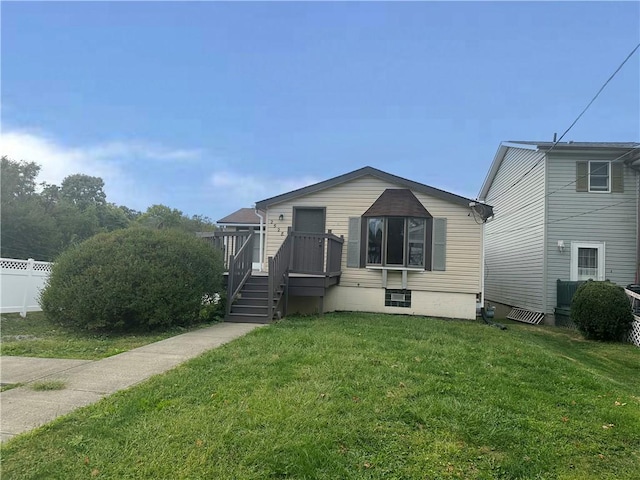 view of front of property featuring a front yard and a deck