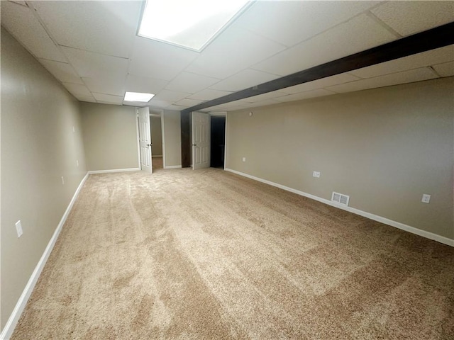 basement with a drop ceiling and carpet flooring