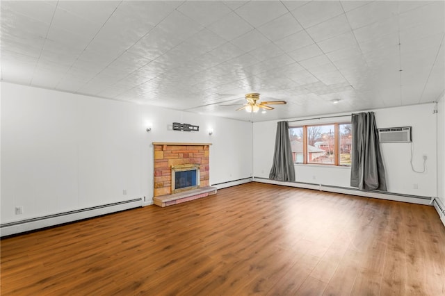 unfurnished living room featuring hardwood / wood-style flooring, a stone fireplace, a wall mounted AC, and a baseboard heating unit