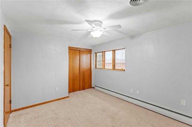 unfurnished bedroom featuring light carpet, a baseboard radiator, a closet, and ceiling fan