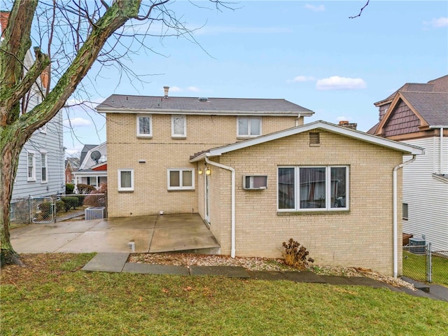 back of property with a lawn and a patio area