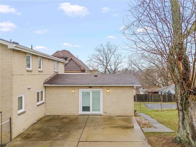 back of property featuring a patio and a lawn