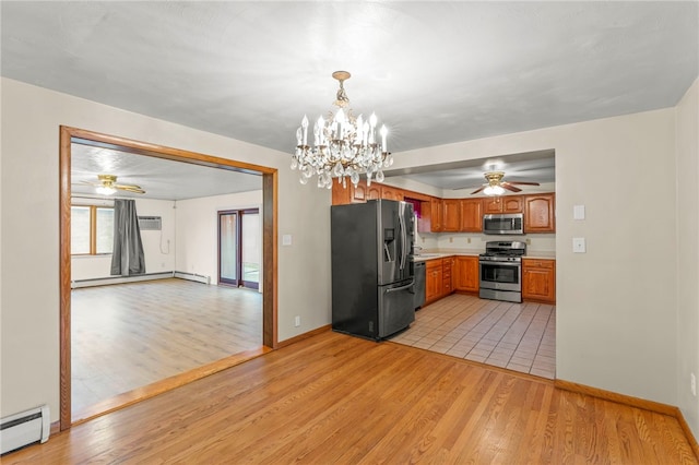 kitchen featuring stainless steel appliances, hanging light fixtures, a baseboard heating unit, and light wood-type flooring