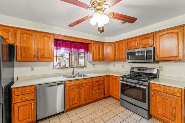 kitchen featuring ceiling fan, stainless steel appliances, sink, and light tile patterned floors