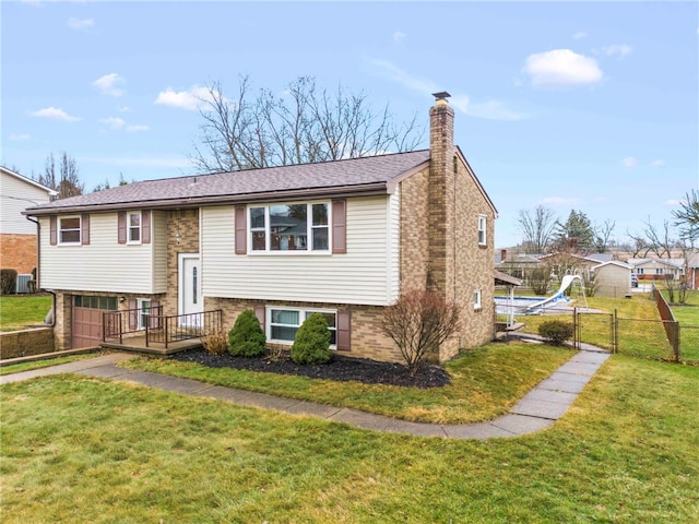 bi-level home with central air condition unit and a front lawn