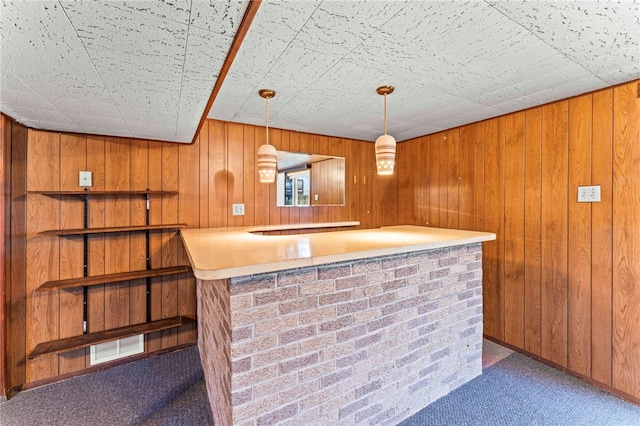 bar featuring decorative light fixtures, carpet floors, and wood walls