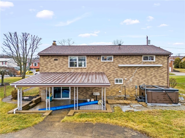 back of house featuring a hot tub, a patio, and a yard