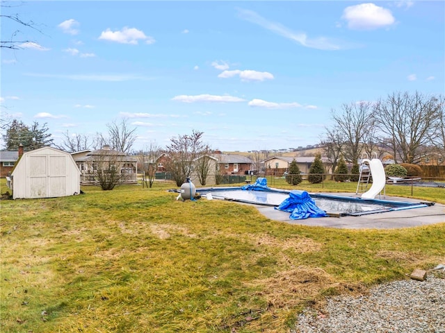 view of yard featuring a storage unit and a covered pool