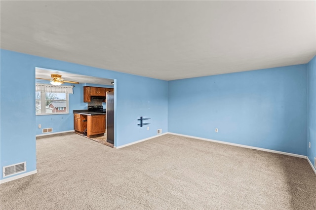 unfurnished living room featuring light carpet and ceiling fan