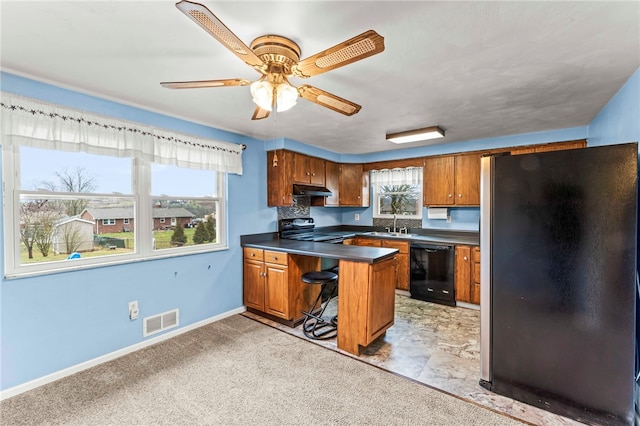 kitchen with stainless steel refrigerator, dishwasher, a kitchen breakfast bar, kitchen peninsula, and electric stove