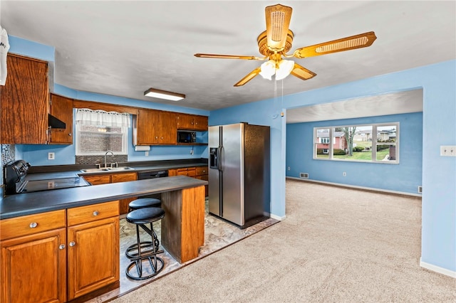 kitchen with a breakfast bar, sink, range, stainless steel fridge with ice dispenser, and light colored carpet