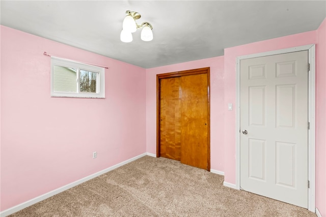 unfurnished bedroom featuring light colored carpet and a closet