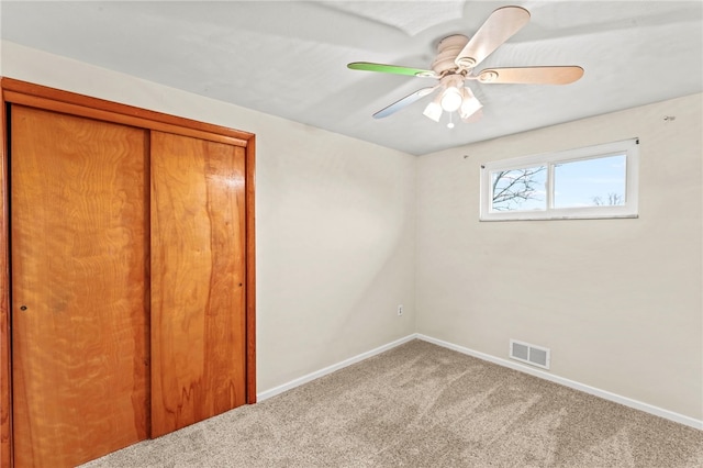 unfurnished bedroom with carpet, ceiling fan, and a closet