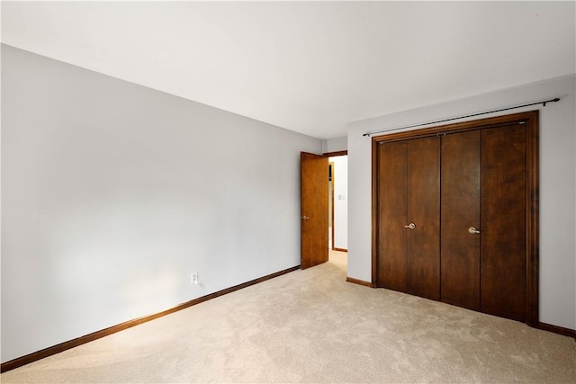 unfurnished bedroom with light carpet and a closet