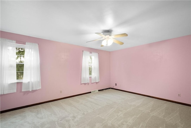 empty room with ceiling fan and light carpet