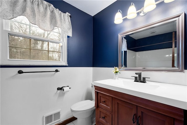 bathroom with walk in shower, vanity, and toilet