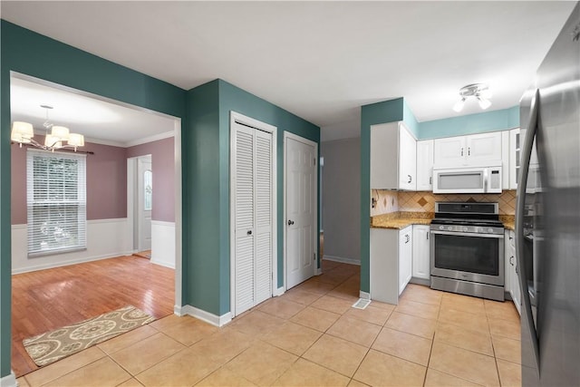 kitchen with white cabinetry, light tile patterned floors, and appliances with stainless steel finishes