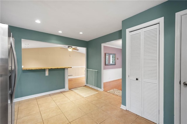 interior space featuring lofted ceiling, stainless steel fridge with ice dispenser, light tile patterned floors, and ceiling fan