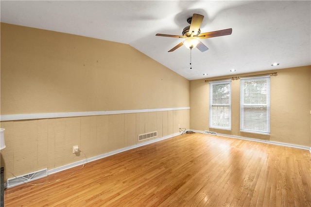 empty room with lofted ceiling, light hardwood / wood-style floors, and ceiling fan