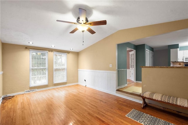 unfurnished living room featuring vaulted ceiling, ceiling fan, and light hardwood / wood-style floors