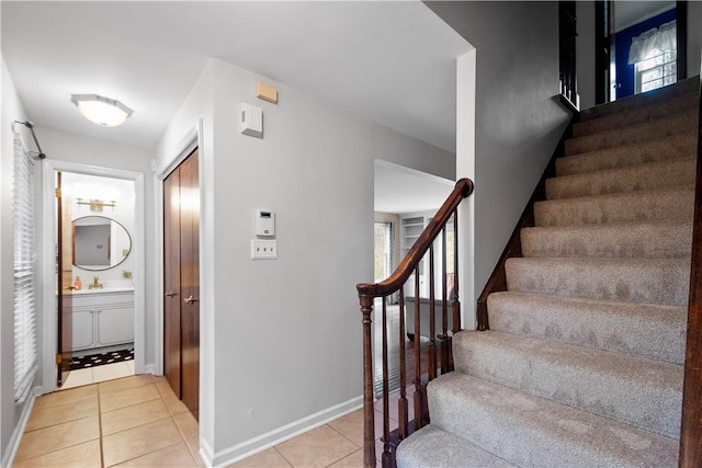 stairway featuring plenty of natural light and tile patterned floors