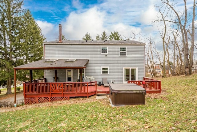 back of property with a hot tub, a yard, and a deck